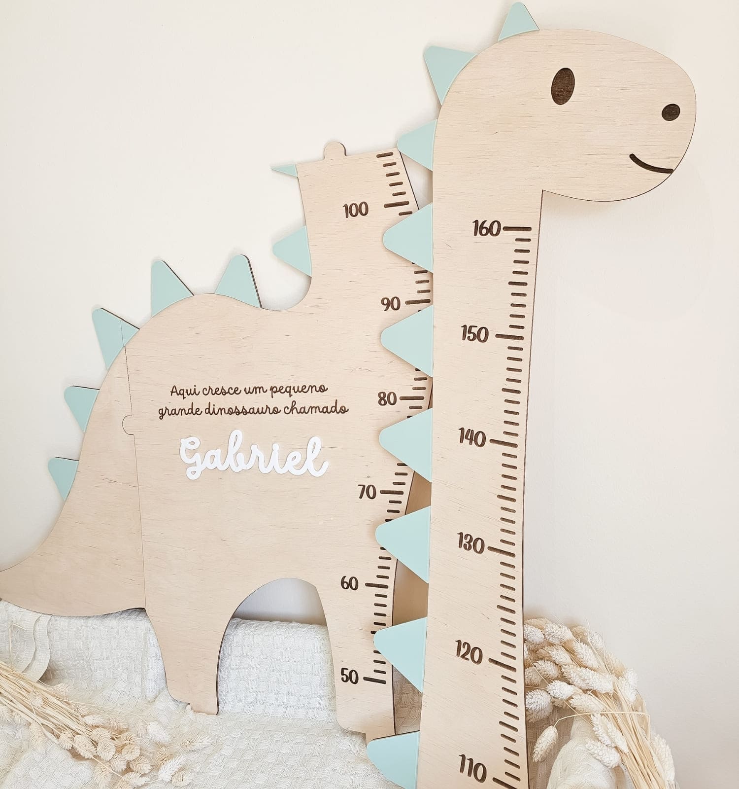 Régua de Crescimento Dinossauro Personalizada - PIPÁPÁ - Amor em Madeira Wooden dinosaur-shaped growth chart with measurement scale and the name Gabriel; a cute baby height ruler in pastel colors, likely for a child’s room.